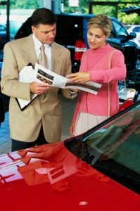 businessman showing woman leaflet in showroom