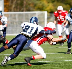 The running back dives for the first down with the defender on his back.